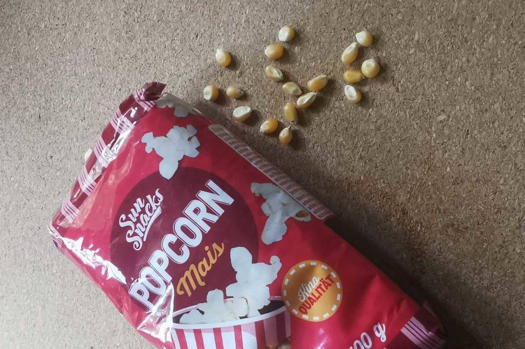 Popcornmais- Verpackung und Körner daneben.