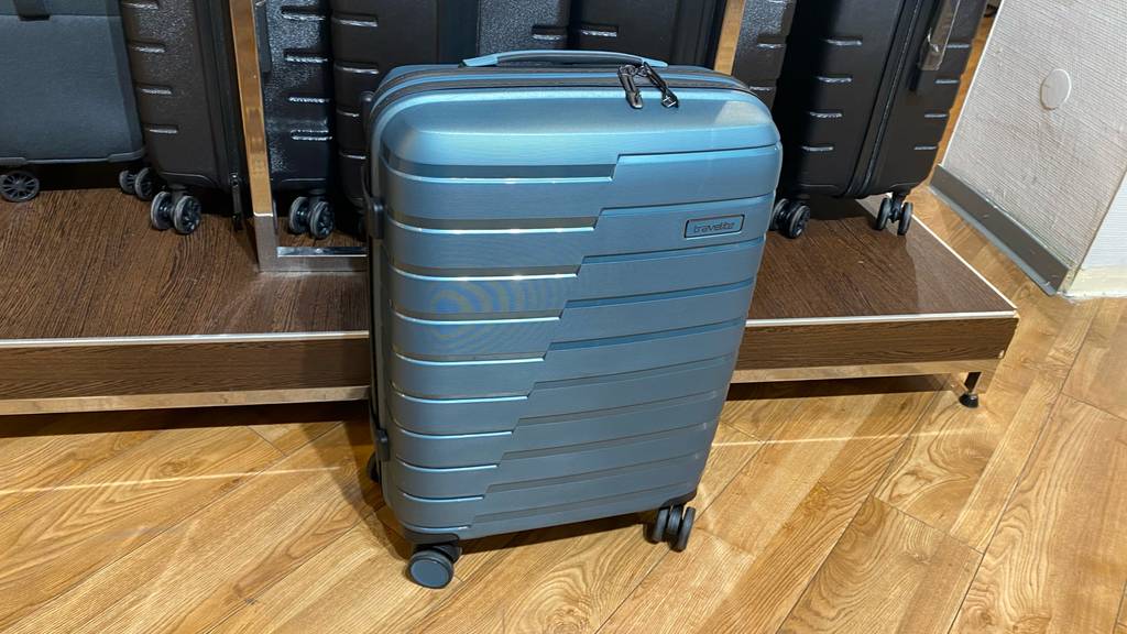 Travelite-Koffer getestet: Ein Koffer steht vor anderen auf einer Holzfläche.