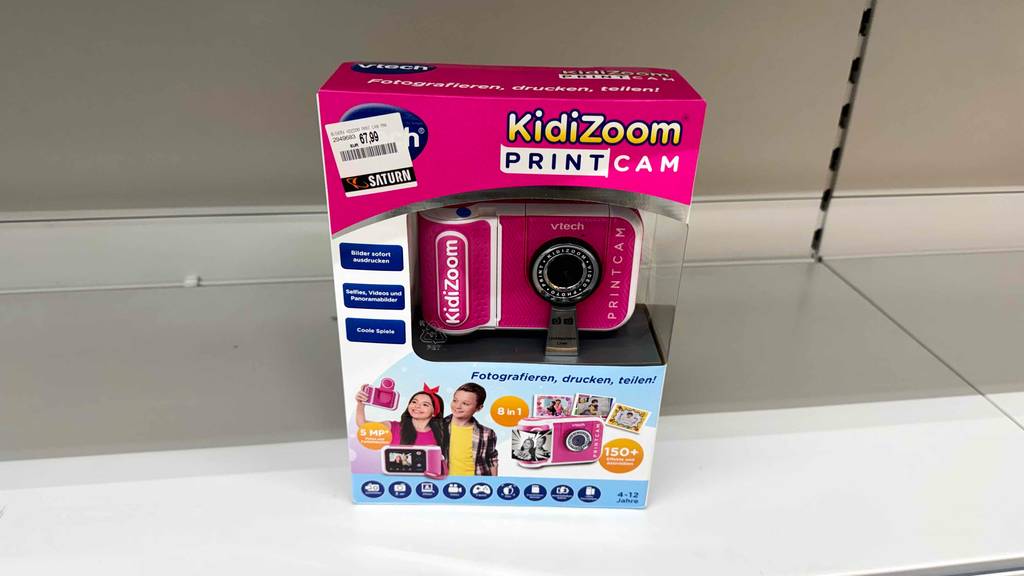 Die getestete VTech-Kinderkamera inklusive Zoom befindet sich in der Verpackung auf einem weißen Verkaufsregal.