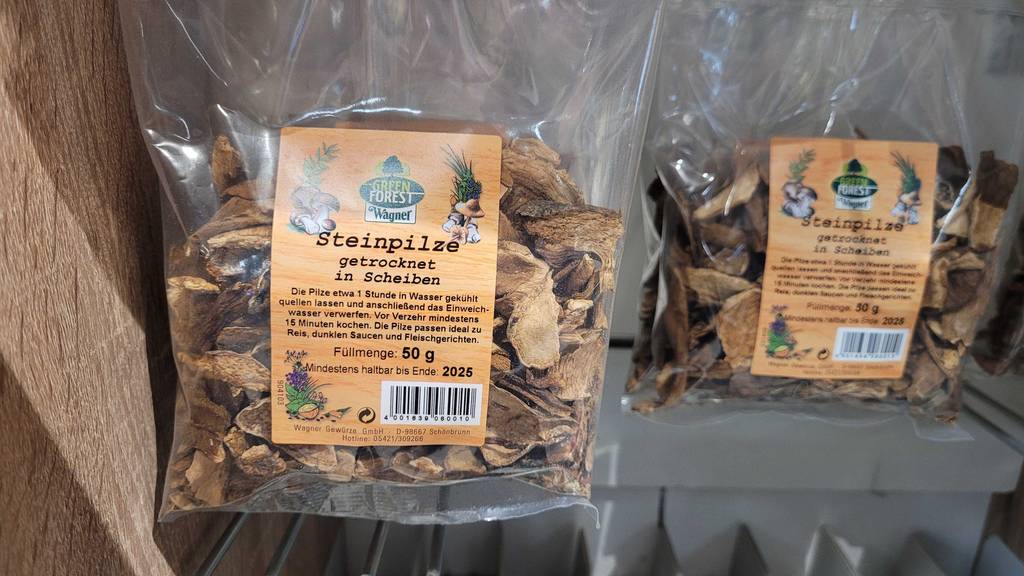 In einem Regal hängen mehrere Packungen der getesteten getrockneten Steinpilze