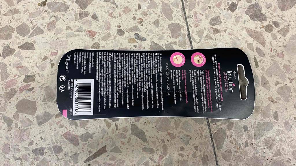 Im Test: Eine Packung Augenbrauenrasierer liegt mir ihrer Rückseite nach oben auf dem Boden
