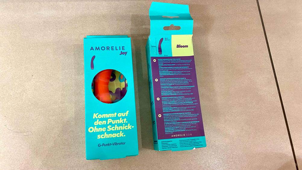 Vibrator-Test: zwei Verpackungen von Vibratoren auf einem Boden platziert, mit Blick auf die Vorder-und Rückseite.