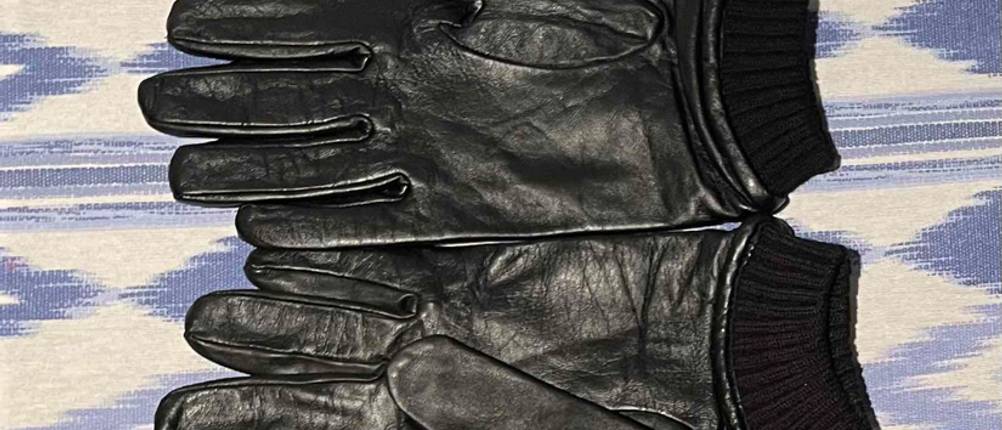 Lederhandschuhe Herren im Test: Zwei Handschuhe nebeneinander auf einer blauweißen Tischdecke