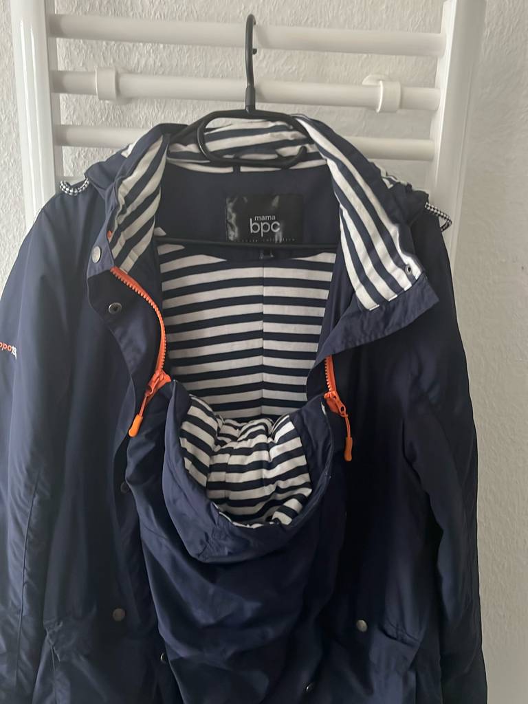 Tragejacke für Damen im Test: eine Tragejacke für Damen mit dem Einsatz fürs Babys hängend auf einem Kleiderbügel.