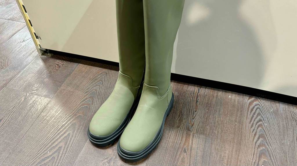 Test: Ein Paar grüne Winter-Gummistiefel stehen auf einem Boden nebeneinander.