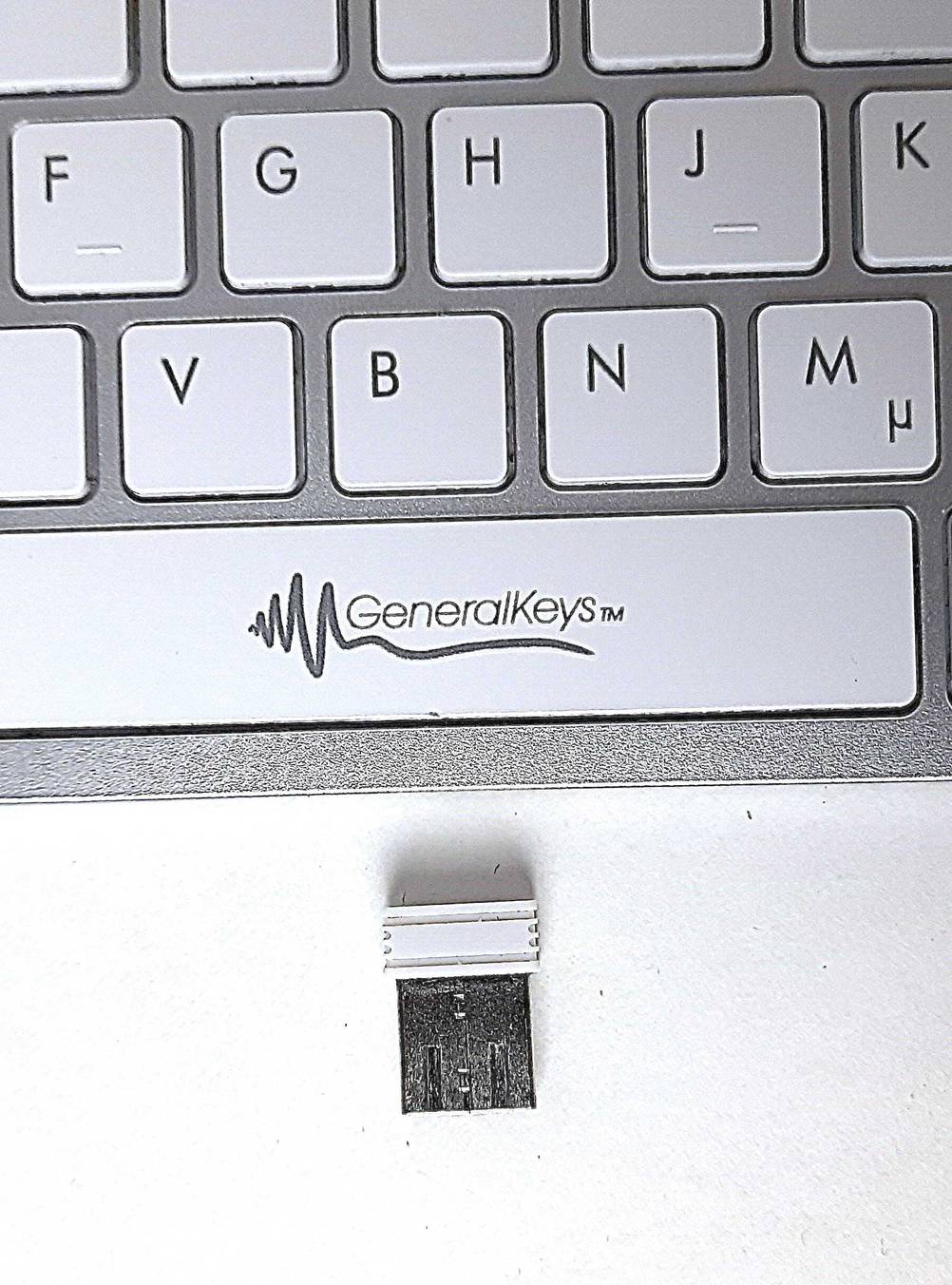 Der dazugehörige USB-Stick der getesteten Aluminium-Tastatur liegt unterhalb der Tastatur.