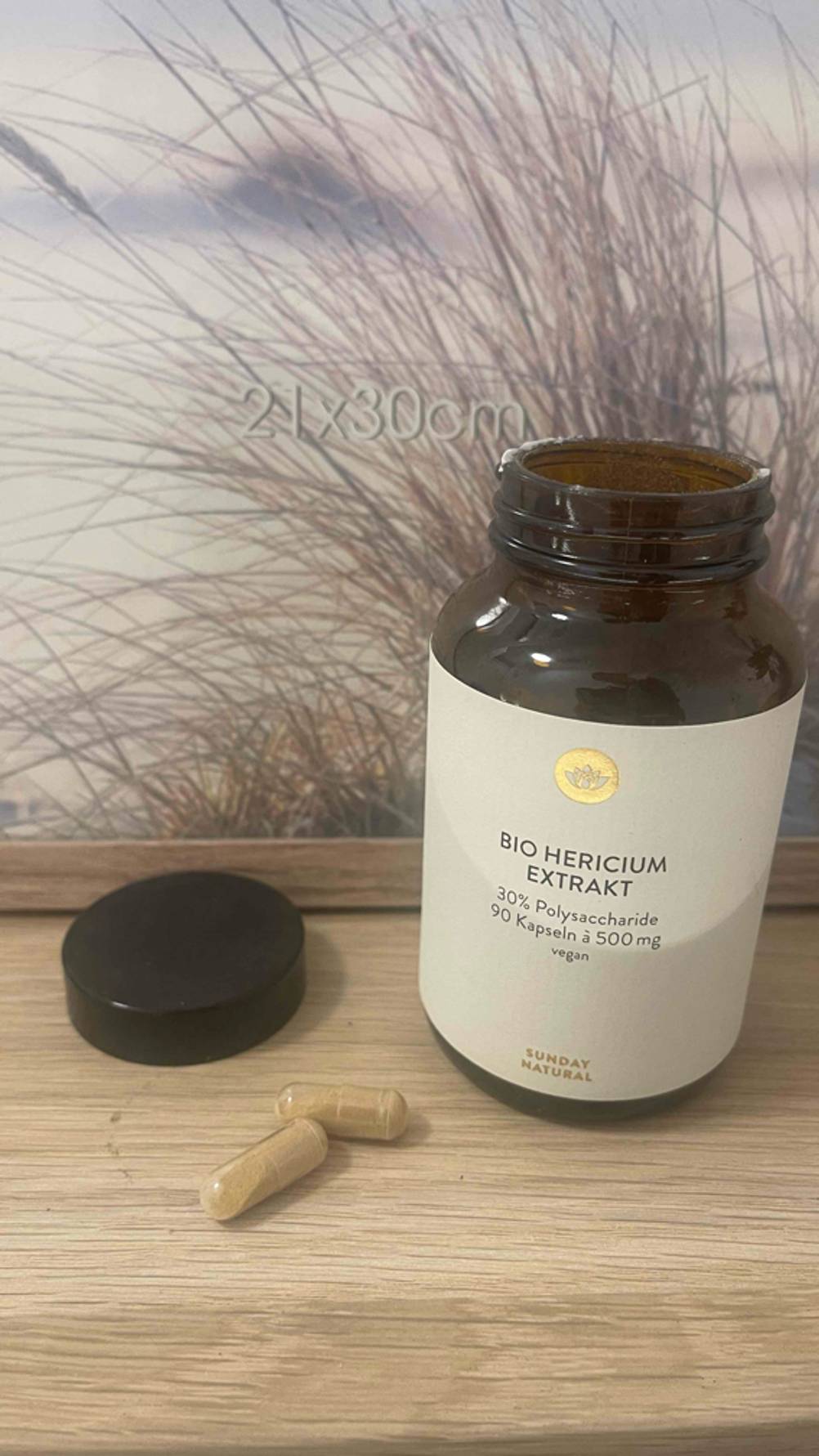 Die geöffnete Dose des getesteten Hericium-Extrakts ist neben zwei Kapseln platziert.