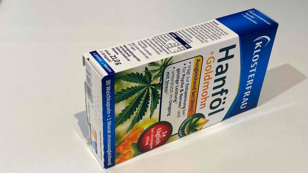 Hanföl-Kapseln liegen in der Verpackung seitwärts auf weißer Fläche