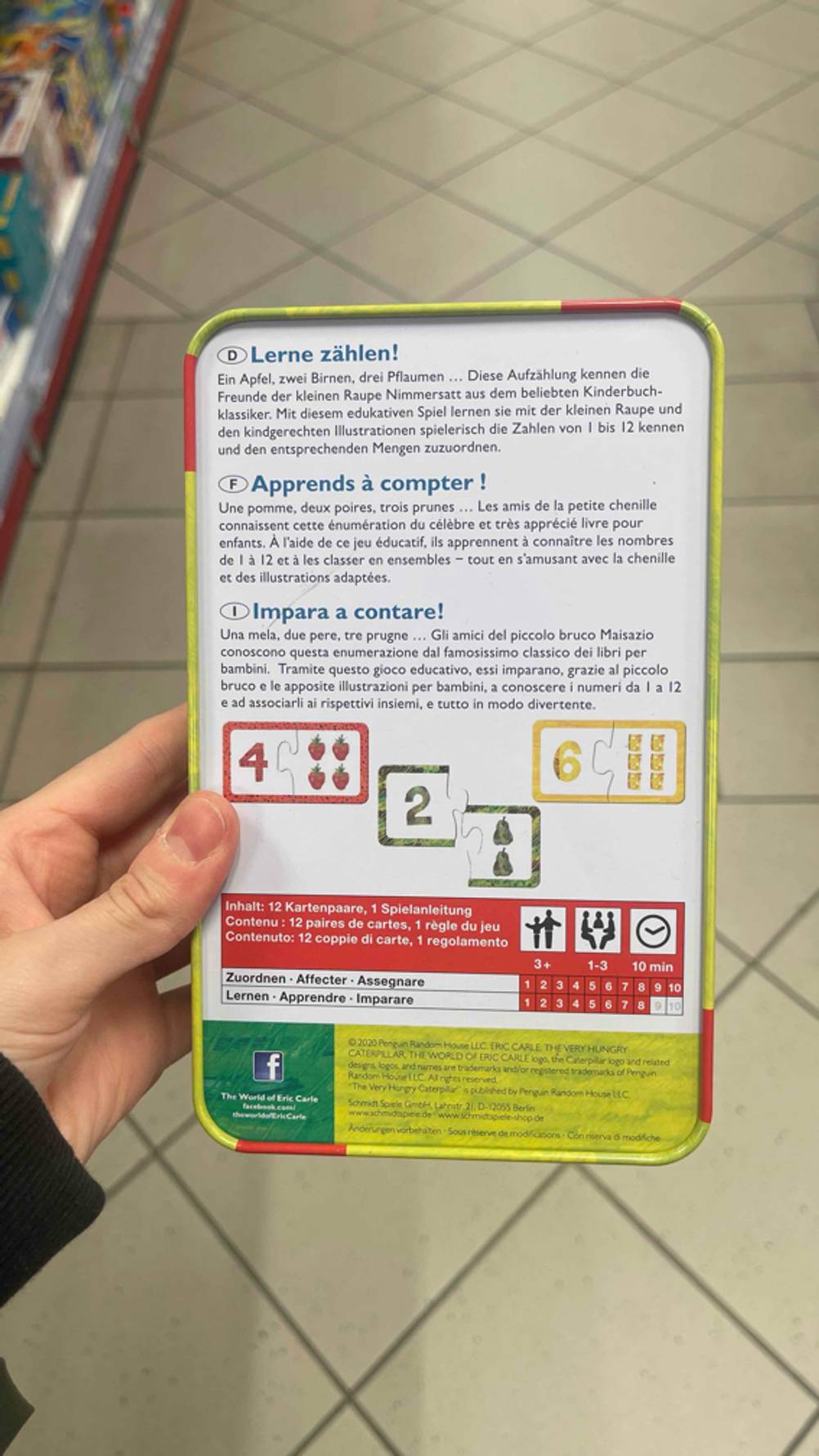 Die Rückseite der Verpackung des getesteten Lernspiels wird in der Hand gehalten.