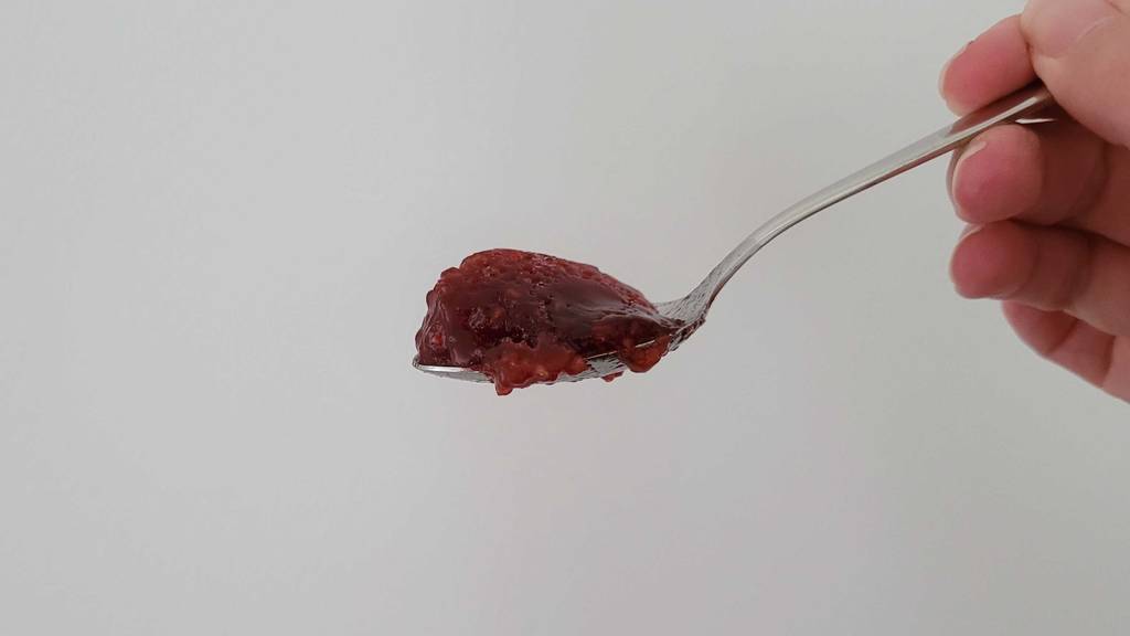 Himbeermarmelade auf einem Löffel.