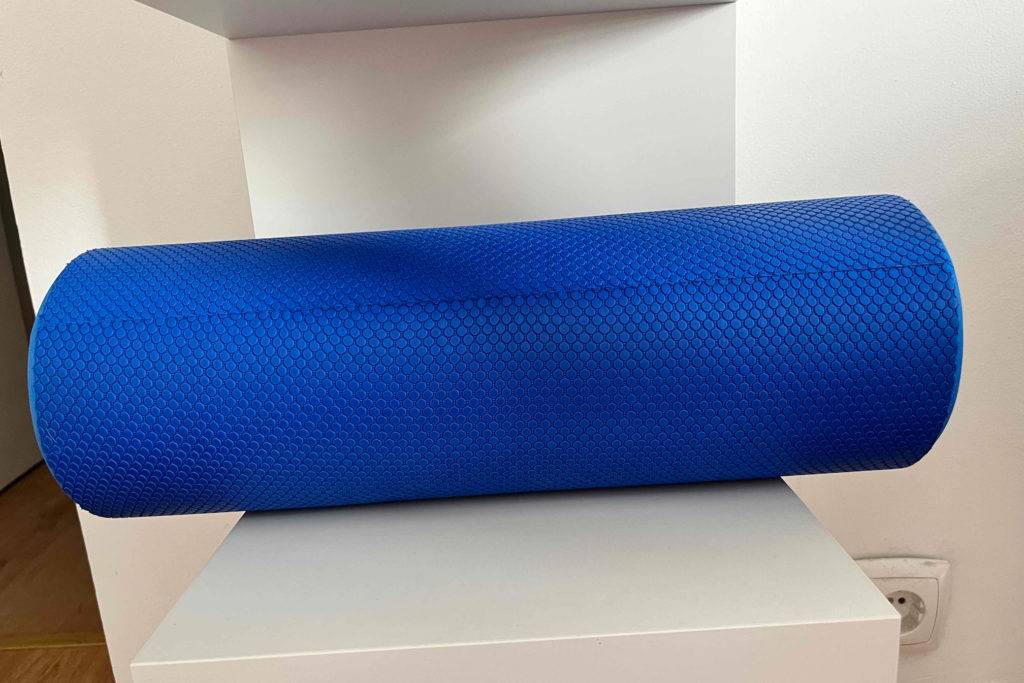 Massageroller im Test: Eine blaue Massagerolle liegt in einem weissen Regal