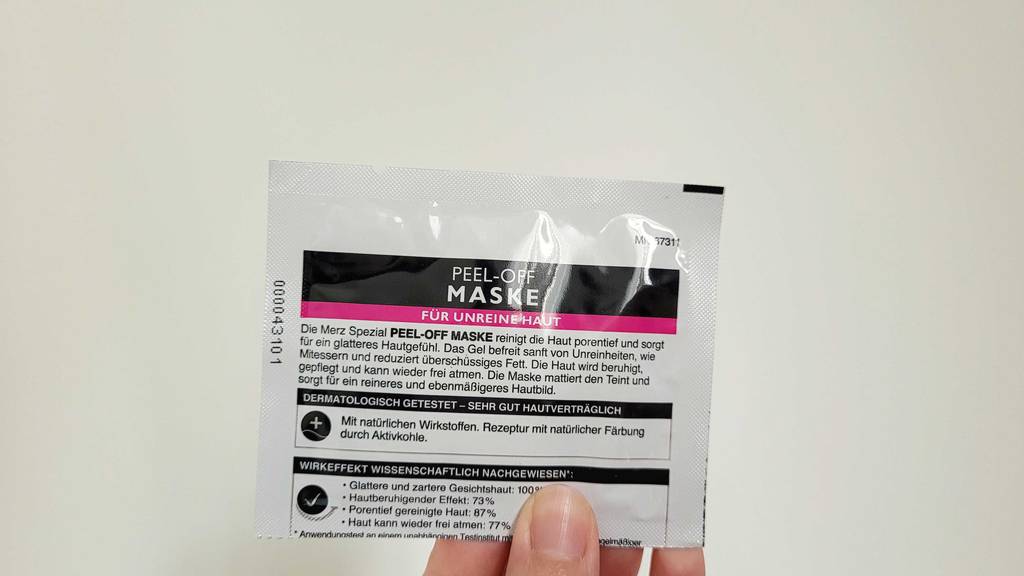 Peel-Off-Maske im Test: Rückseite einer Merz Peel-off-Maske, von einer Hand gehalten.