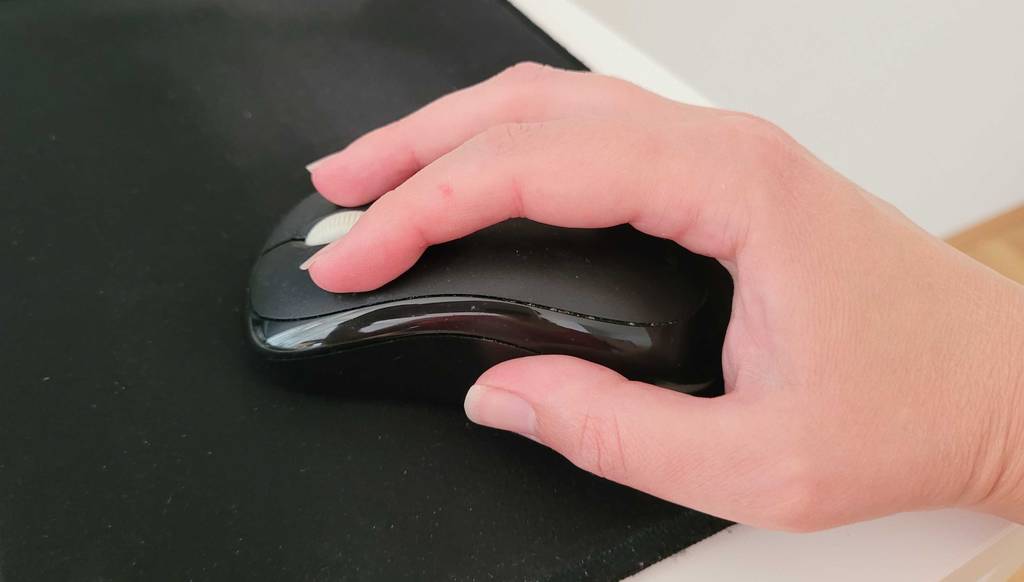 Kabellose Maus in Test: Rechte Hand führt eine kabellose Maus.