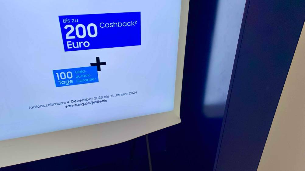 Rahmen eines 65-Zoll-Fernsehers im Fokus mit 200 Euro Cashback und 100 Tage-Geld-zurück-Garantie am Bildschirm ersichtlich.
