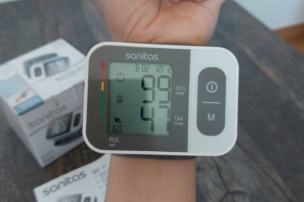 Sanitas-Blutdruckmessgerät getestet: Das Messgerät ist an einem Handgelenk angebracht, die Digitalanzeige ist eingeschaltet