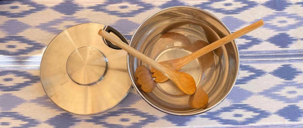 Salatschleuder Edelstahl getestet: In einer Salatschleuder liegt Salatbesteck daneben der Deckel