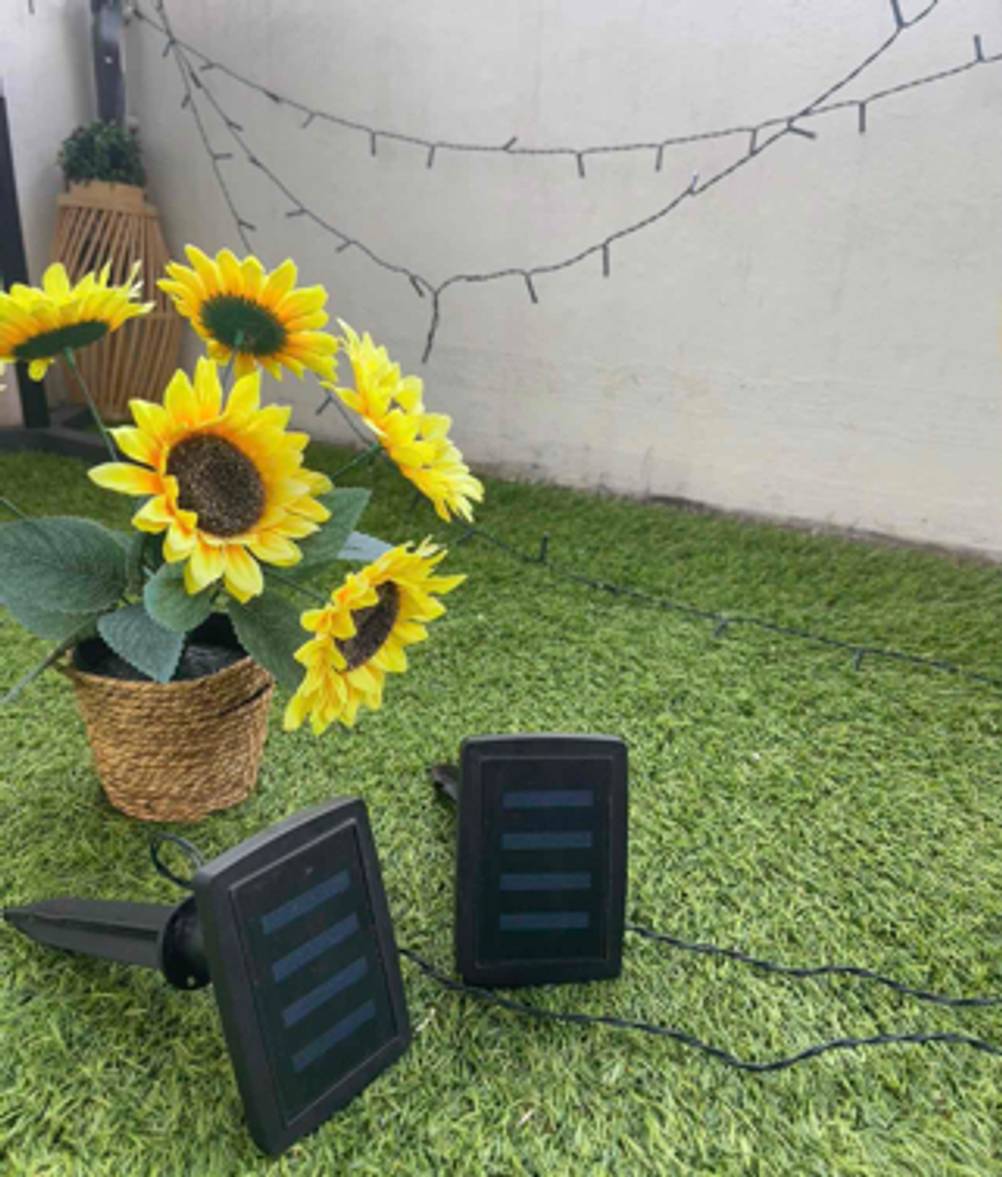 Das Solarpanel einer Solar-Lichterkette, die getestet wurde liegt auf einem Kunstrasen.