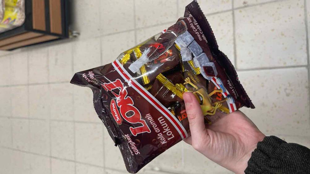 Die getesteten türkischen Süßigkeiten, die sich in einer Kunststofftüte befinden, werden in der Hand gehalten.