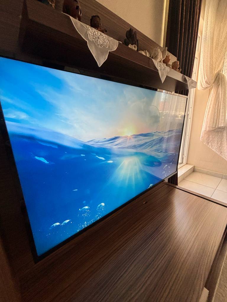 Smart-TV im Test: ein Smart-TV mit einer Berglandschaft als Hintergrund steht in einer Wahnwand eingebettet.