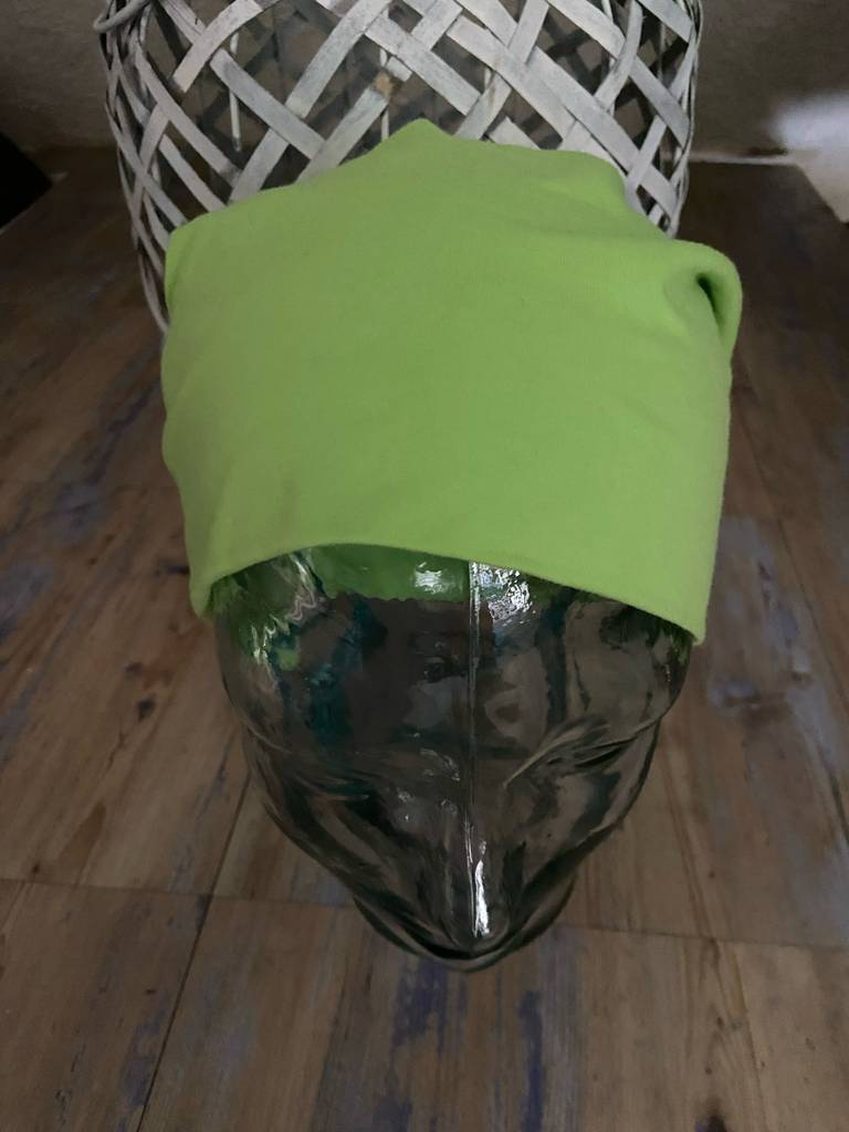 Beanie im Test: Eine grüne Mütze befindet sich auf einem Glaskopf.