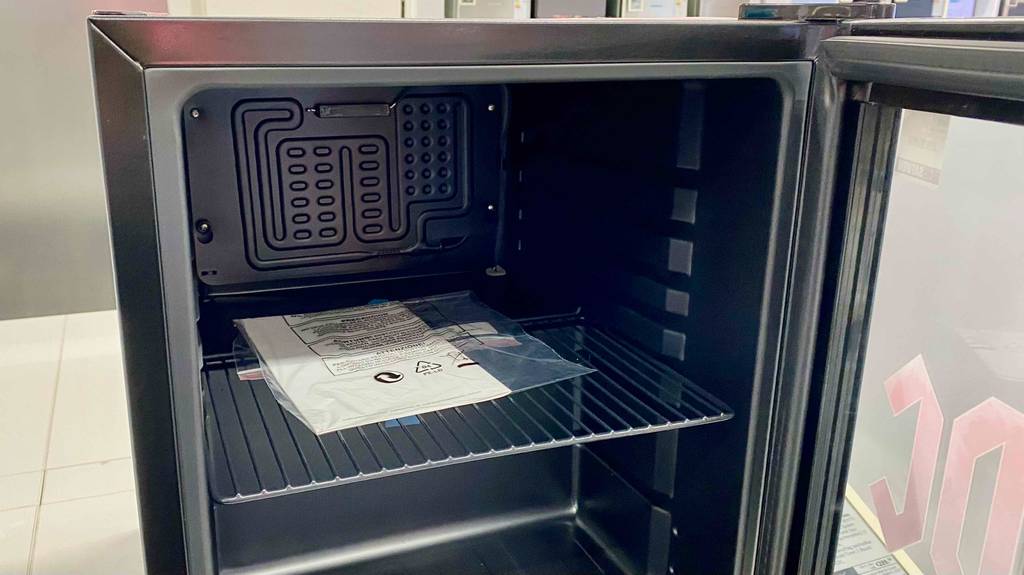 Mini-Kühlschrank im Test: Innenansicht eines Mini-Kühlschranks mit Gebrauchsanweisung darin liegend.