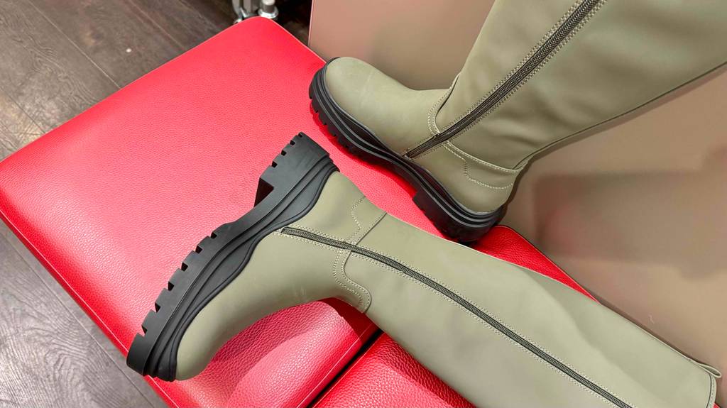 Die getesteten Winter-Gummistiefel sind auf einem roten Sitzhocker platziert, mit Blick auf die Reißverschlüsse.