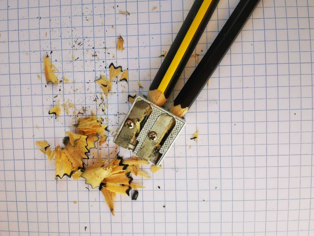 Anspitzer getestet: Ein Modell aus Metall liegt mit zwei Stiften, die gespitzt wurden, auf dem Rechnerpapier.