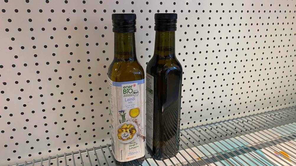 Leinöl getestet: Zwei Flaschen vor einer hellen Fläche, eine von vorne, eine von hinten.