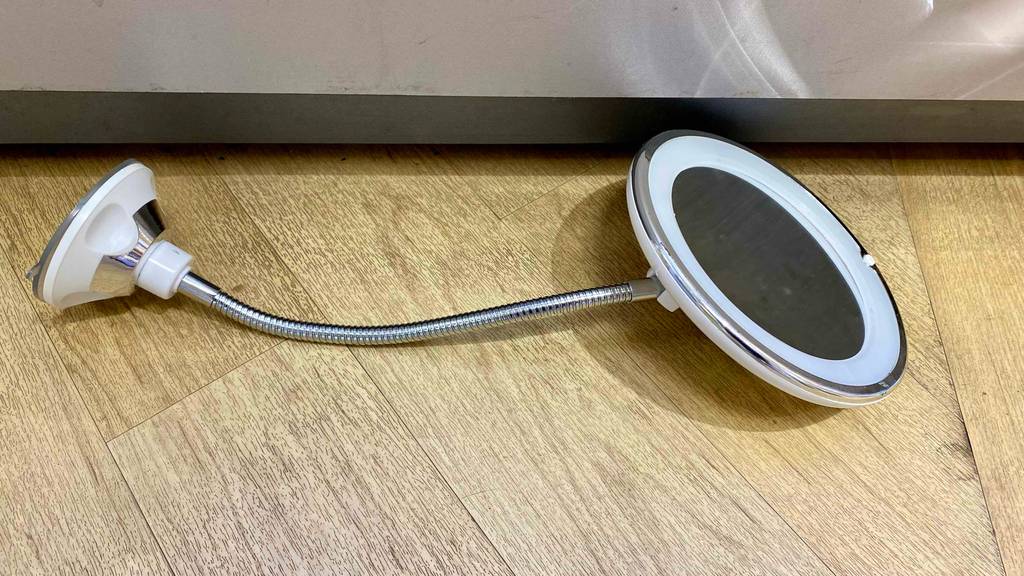 Beleuchteter Kosmetikspiegel-Test: Das Produkt liegt auf einem Holzboden.