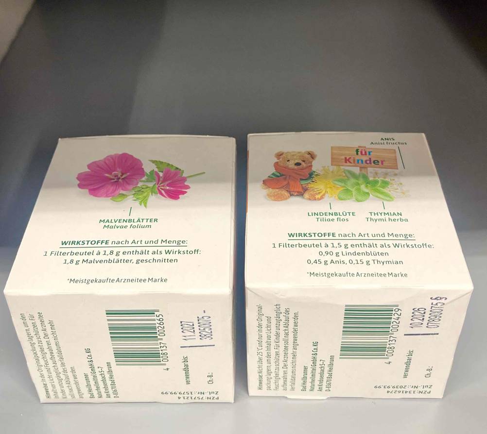 Zwei getestete Hustentees liegen auf einer grauen Fläche.