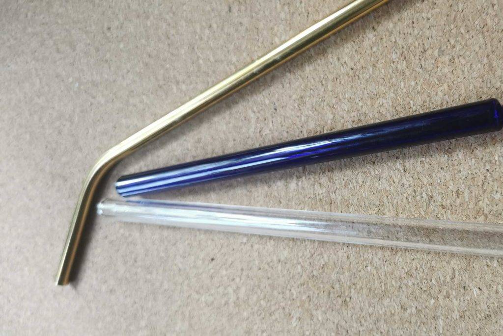 Verschiedene Glas-Strohhalme liegend.