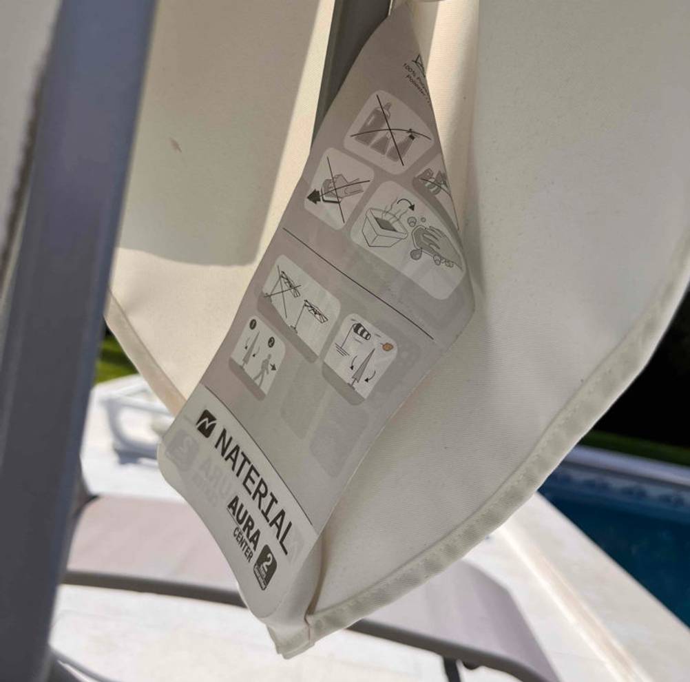 Sonnenschirm-Test: Etikett von weißem Sonnenschirm in Nahaufnahme.