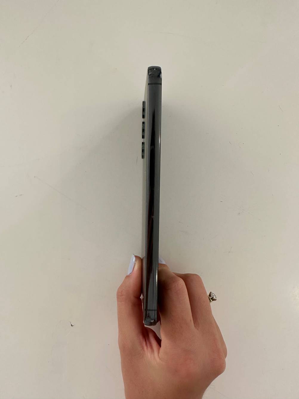 Eine Hand hält ein getestetes Samsung-Smartphone seitlich vor eine helle Wand.