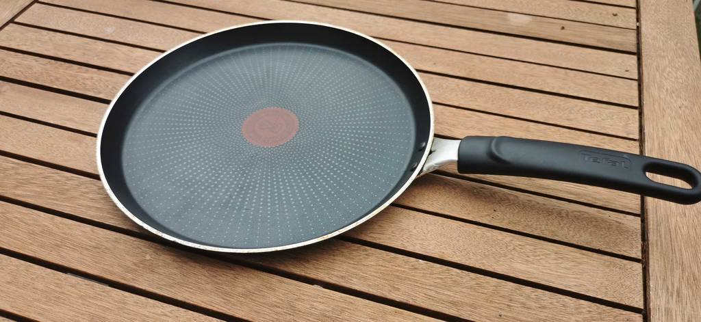 Crepes-Pfanne auf einem Holztisch.