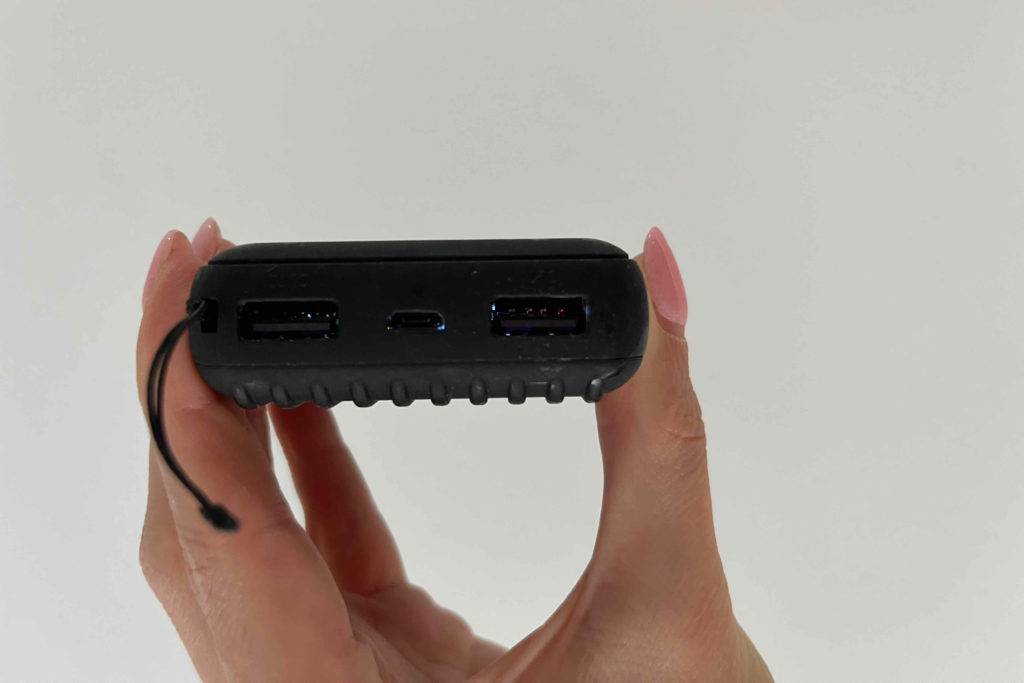Powerbank 10000mah im Test: Eine Hand hält die Powerbank so daß man die Anschlüsse sehen kann