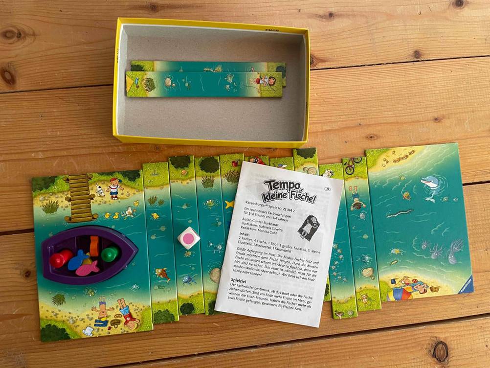 Würfelspiel-Test: der Inhalt eines Würfelspiels ist vor der Verpackung platziert, mit Spielanleitung darauf.