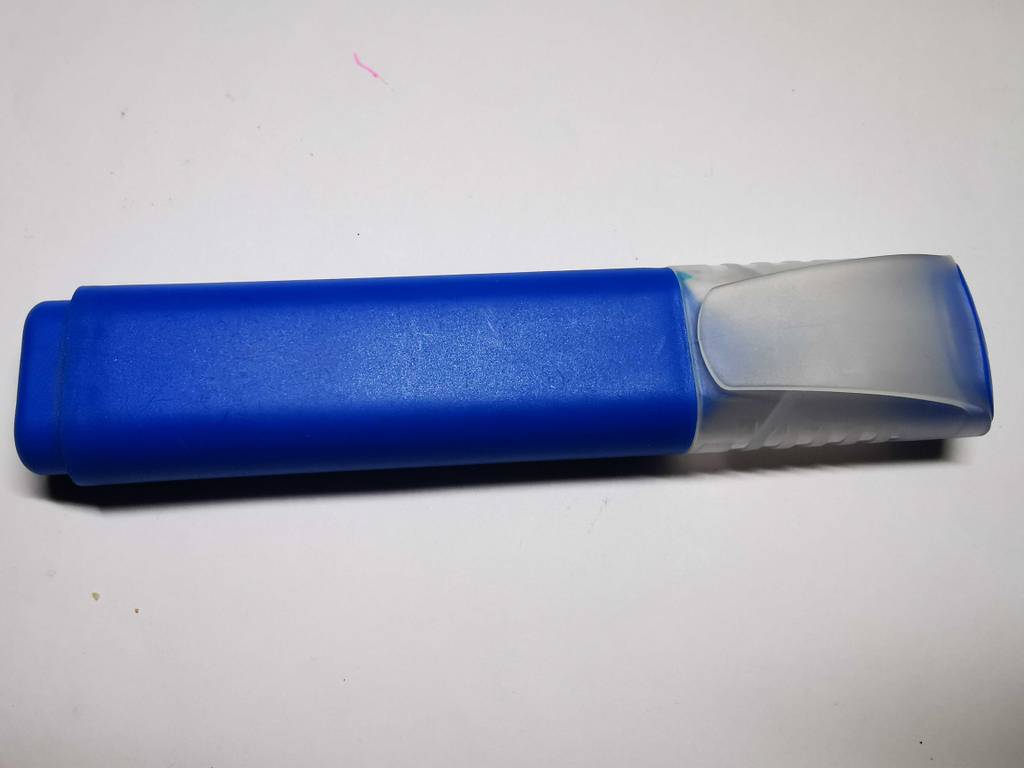 Ein blauer Textmarker im Test liegt auf einer weißen Oberfläche.