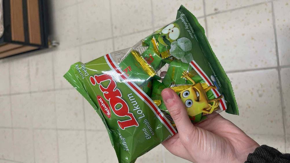 Die getesteten türkischen Süßigkeiten, die sich in einer Tüte befinden und darin noch einzeln verpackt sind, werden in der Hand gehalten.