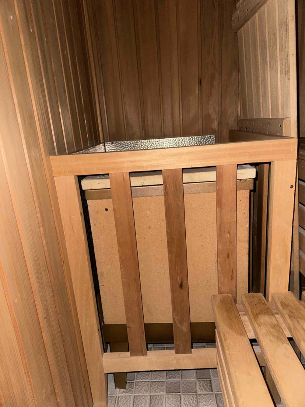 Sauna -Test: Frontaufnahme des Saunaofens mit Schutzgitter davor.