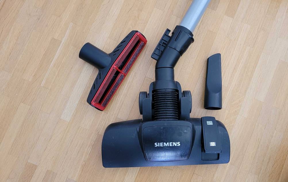 Siemens-Staubsauger getestet: Eine Saugbürste und anderes Zubehör auf einem Holzboden.
