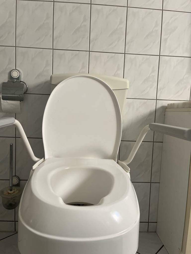Test: die geöffnete Toilettensitzerhöhung von vorn ersichtlich.