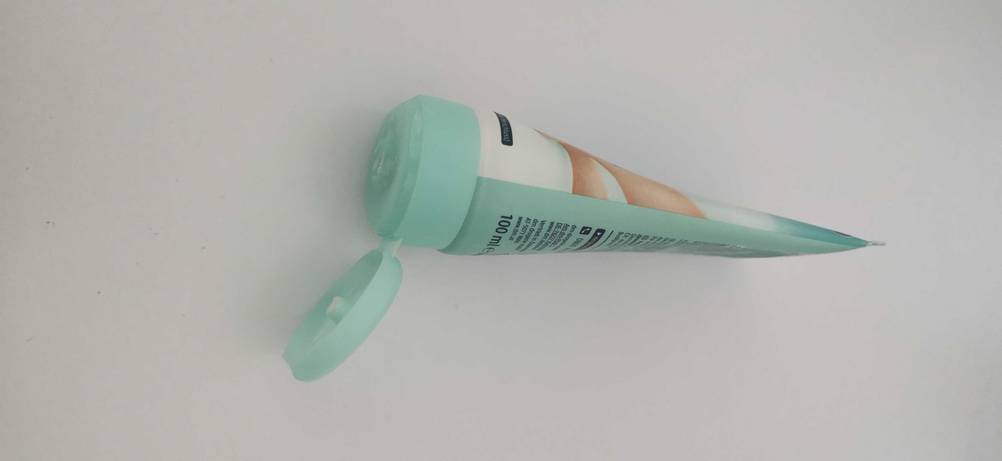 Fußcreme im Test: eine geöffnete Tube Fußcreme auf einer weißen Fläche liegend.