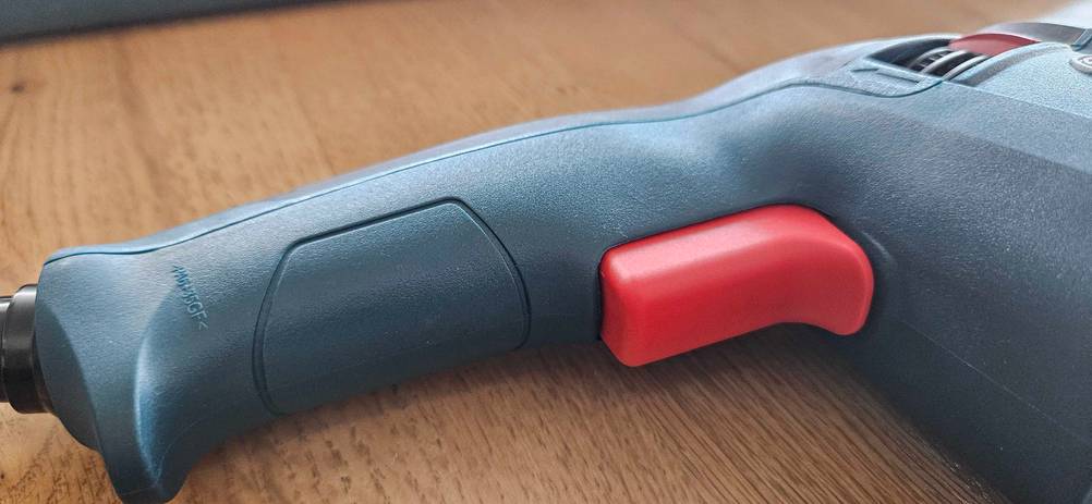 Bosch-Bohrhammer-Test: roter Knopf eines Bosch-Bohrhammers in Nahaufnahme.