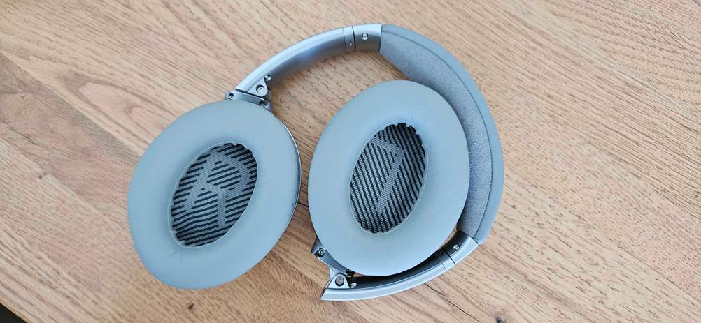 Ein Over-Ear-Kopfhörer im Test liegt umgedreht auf einer Holzfläche.