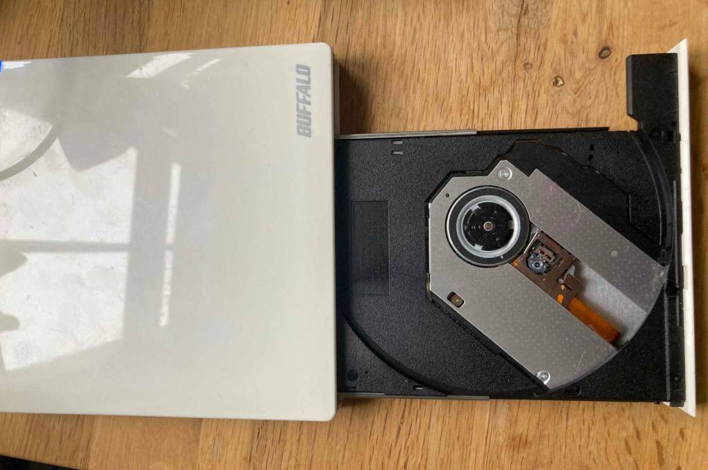 Im Test: Ein Externes DVD-Laufwerk mit geöffneter Lade auf einer Holzoberfläche.