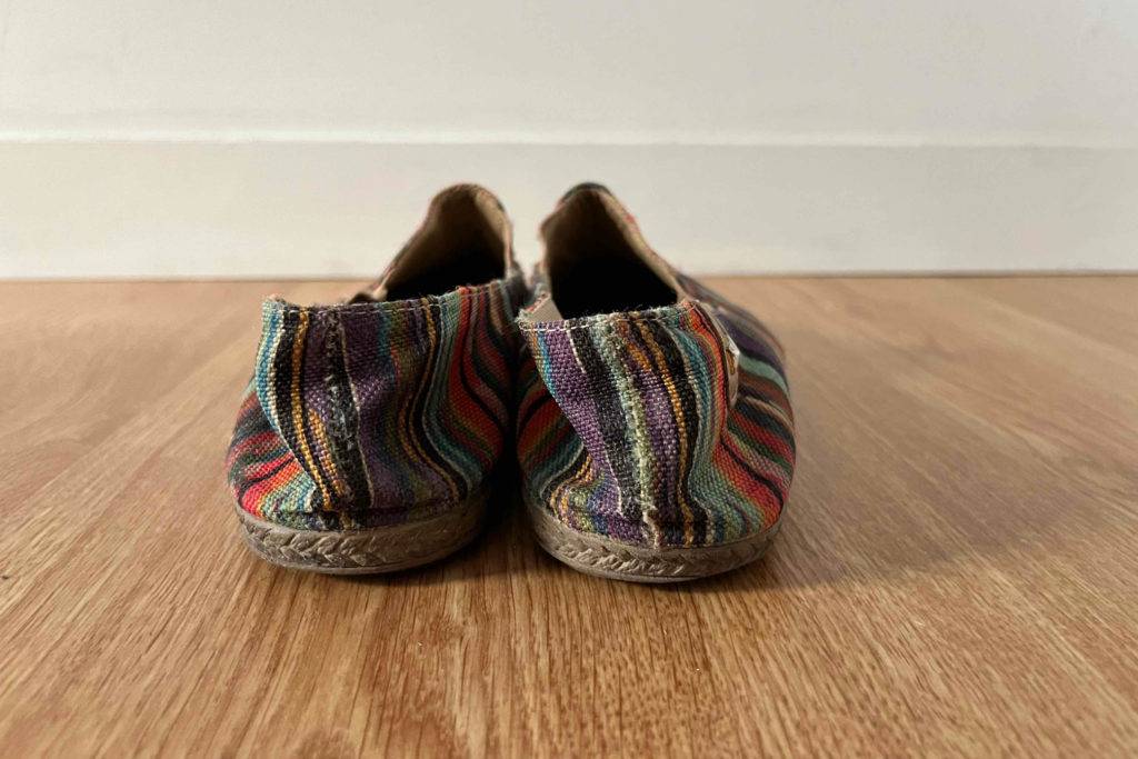 Espadrilles für Damen im Test: Schuhe von hinten auf Holzfläche