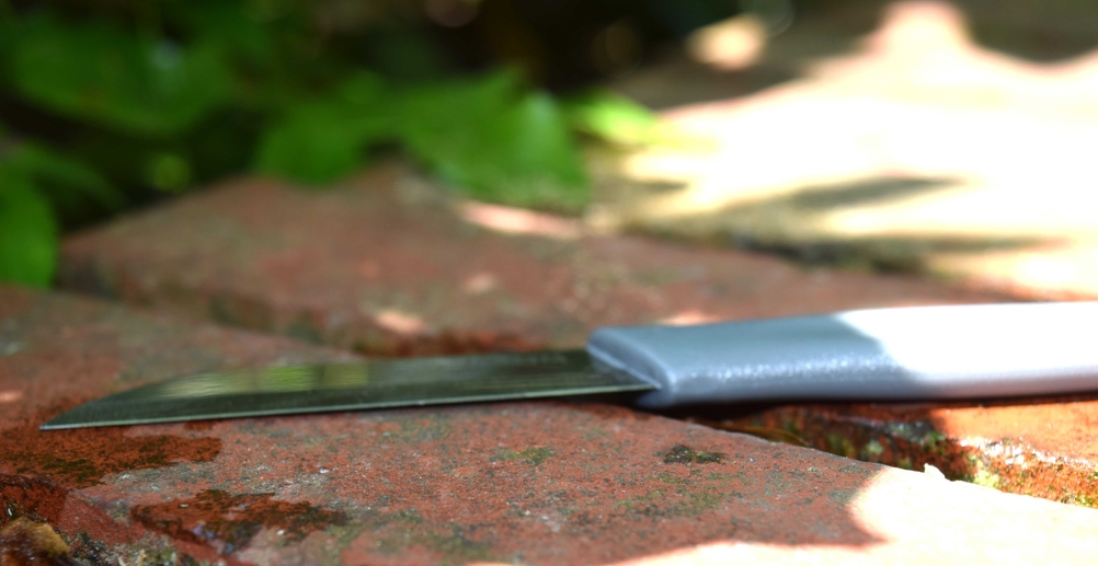 Gemüsemesser liegt auf einem Steinboden.