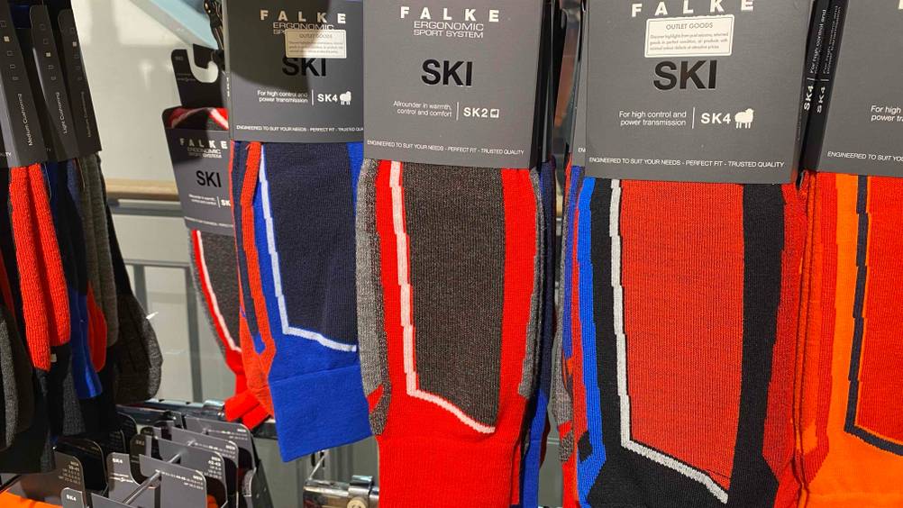 Skisocken-Test: mehrere Paar Skisocken hägend in einem Regal.