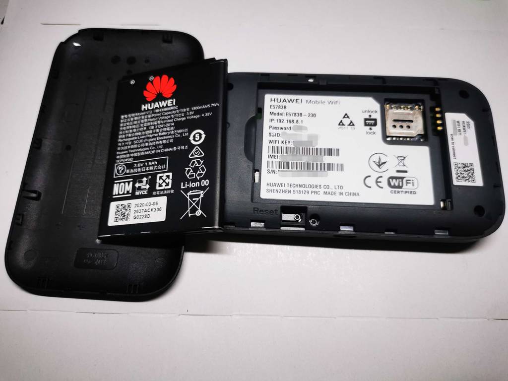Der schwarze Huawei-Router im Test steht inklusive Ionen-Batterie geöffnet auf einer weißen Oberfläche.