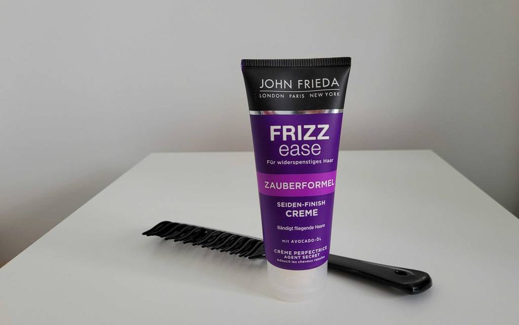 John Frieda Frizz Ease Haarcreme neben einen Kamm